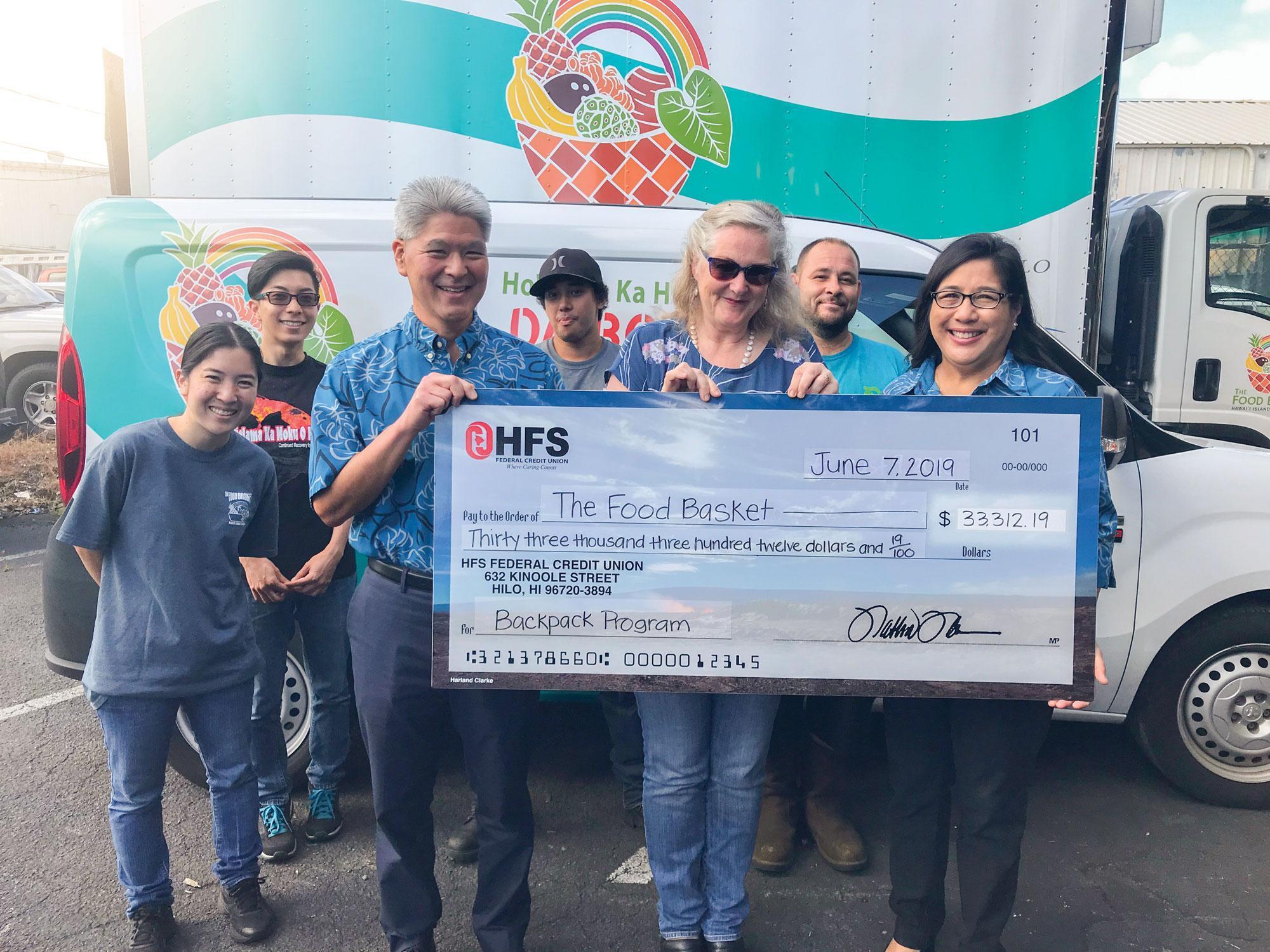 HFS and Food Basket staff smile with the donation check