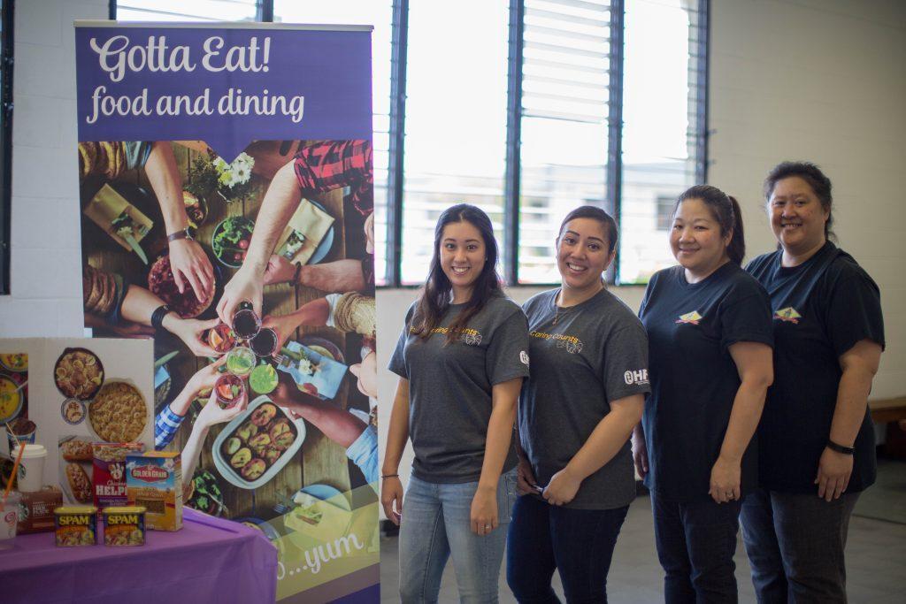staff and volunteers at the HFS Reality Fair stand next to their booth