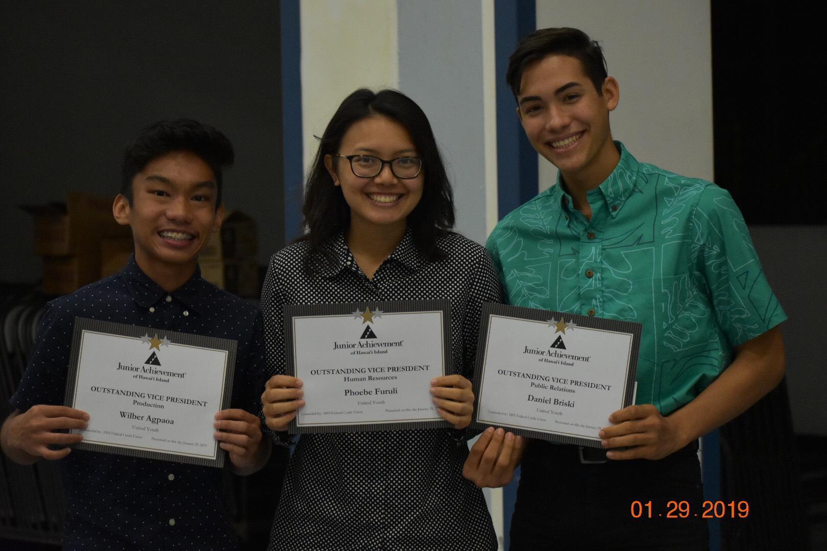Students from United Youth, a Junior Achievement Company, smile as they hold the certificates for the awards they won at the end of the year banquet