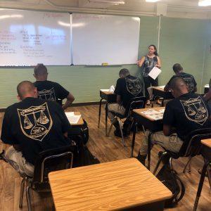 HFS staff member stands in front of the room speaking to a group of students 