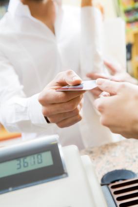 man doing shopping in a grocery store and paying by credit card